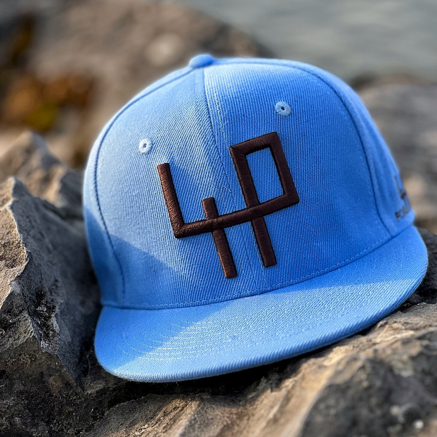 exclusive attire blue cap on rock, leman lake, switzerland